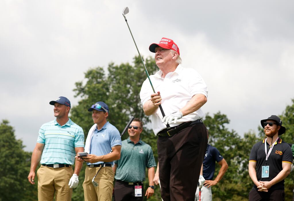 Former US president Donald Trump plays his shot from the seventh tee as Bryson DeChambeau looks on during the pro-am prior to the LIV Golf Invitational at Trump National GC Bedminster in Bedminster, New Jersey. Photograph: Cliff Hawkins/Getty Images