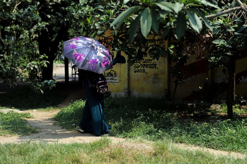 A pedestrian uses an umbrella to take shelter from the sun during high temperatures in Dhaka, Bangladesh, recently.  Photograph: Anik Rahman/Bloomberg