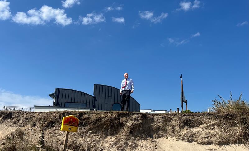 Billy Kell on the heavily eroded bank separating Kelly's Hotel from the beach at Rosslare Strand. Photograph: Steven Carroll