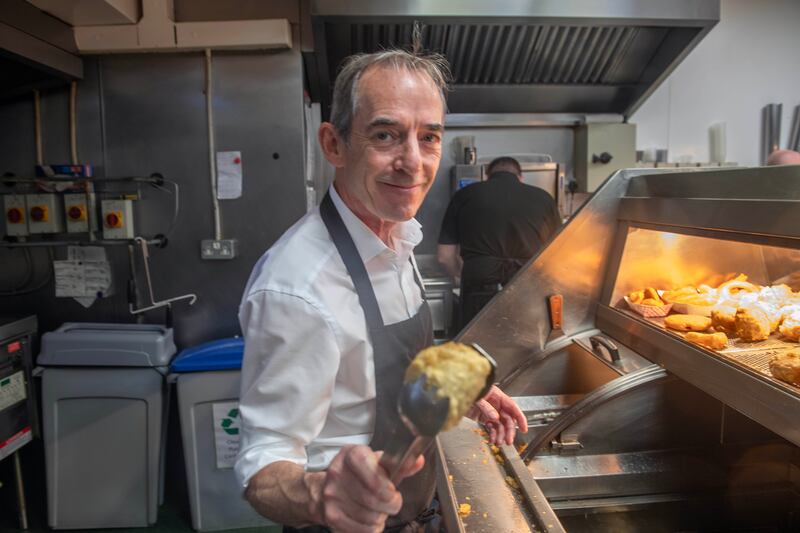 Owner Brian Lennox serving  in Lennox's chip shop in Cork, which is closing on Sunday. Photograph: Michael Mac Sweeney/Provision