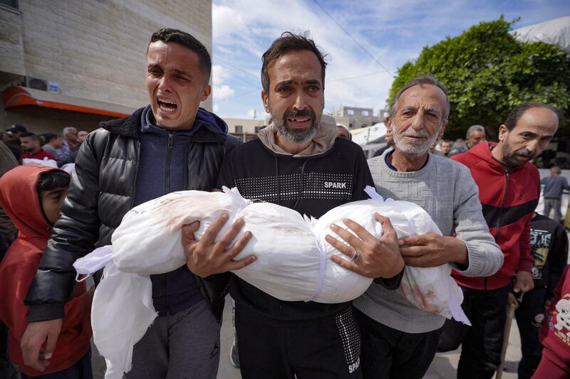 A Palestinian man carries the body of a child killed in an Israeli bombing in Deir el-Balah in the central Gaza Strip on Thursday. Photograph: AFP via Getty Images