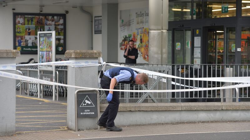 A garda searches for evidence after a shooting outside Lidl on the Blakestown Road in Dublin on Saturday evening. Photograph: Alan Betson