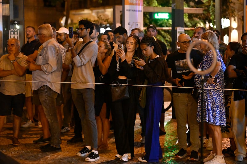 Onlookers stand behind the police line at Praça Restauradores square in Lisbon. Photograph: Horacio Villalobos/Getty Images