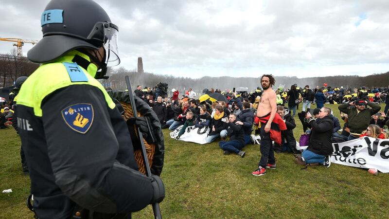 A Dutch anti-riot police officer in a stand-off with a protester. Photograph: Getty