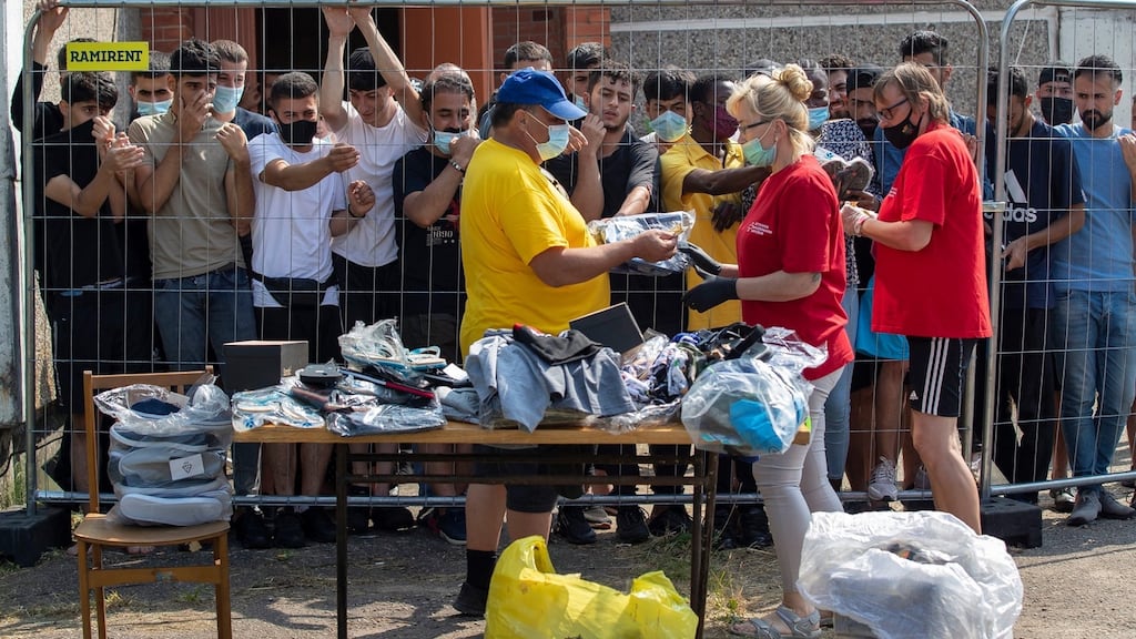 Lithuanians sell things to migrants standing behind the fence at the refugee camp in the village of Verebiejai, Lithuania, on July 11th. Photograph: Mindaugas Kulbis/AP
