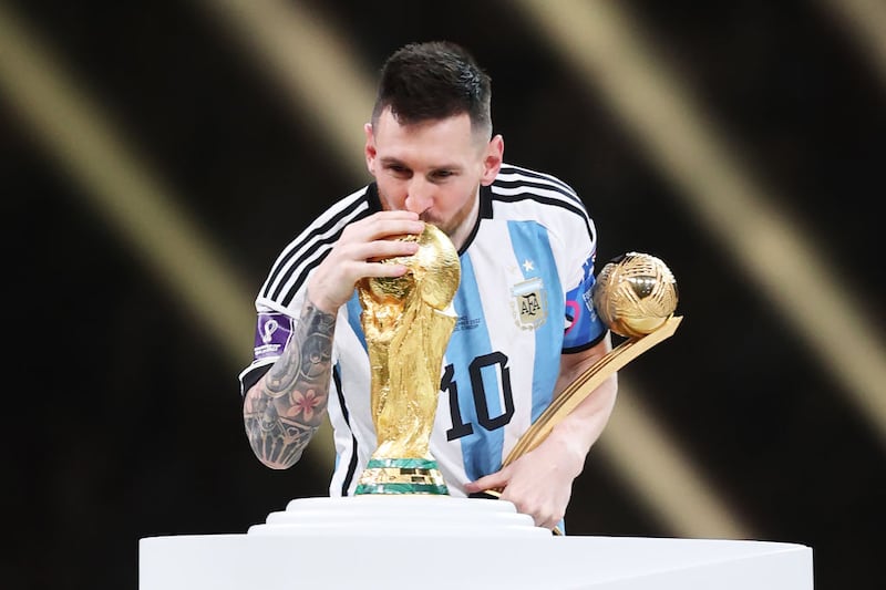 Lionel Messi, then of PSG, gets his hand and lips on the World Cup after victory in Qatar in 2022. Photograph: Julian Finney/Getty Images