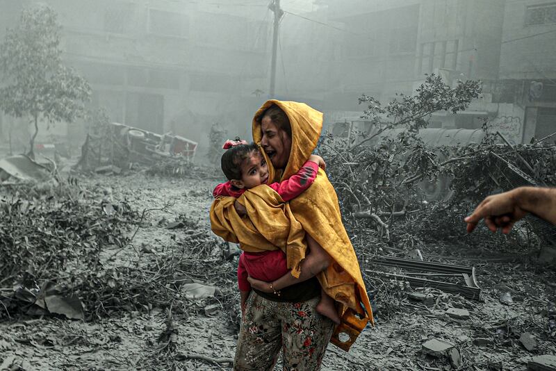 A woman holding a girl reacts after Israeli airstrikes hit Ridwan neighborhood of Gaza City, Gaza yesterday. Photograph: Ali Jadallah/Anadolu via Getty Images