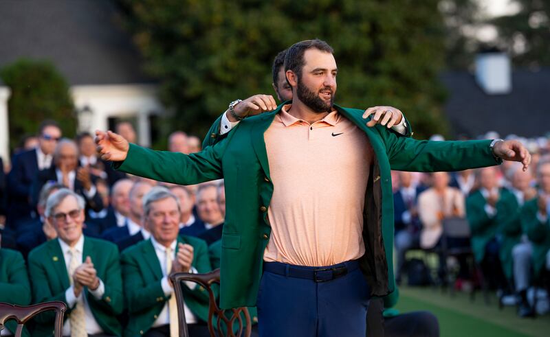 Jon Rahm helps Scottie Scheffler put on his green jacket after Scheffler won the Masters last year. Photograph: Doug Mills/The New York Times
                      