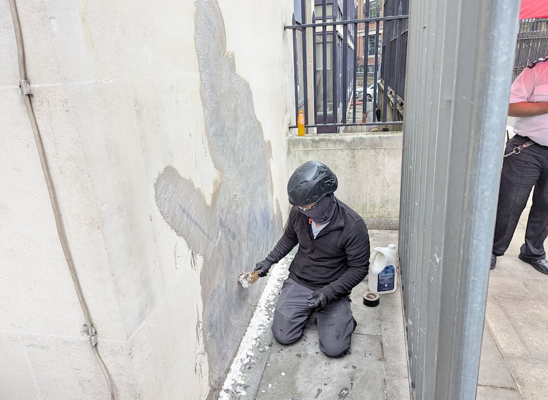 The new artwork by Banksy which shows a judge attacking a protester with a gavel, being removed after it appeared at the Royal Courts of Justice in London on Monday. Photograph: Danny Halpin/ PA Wire 