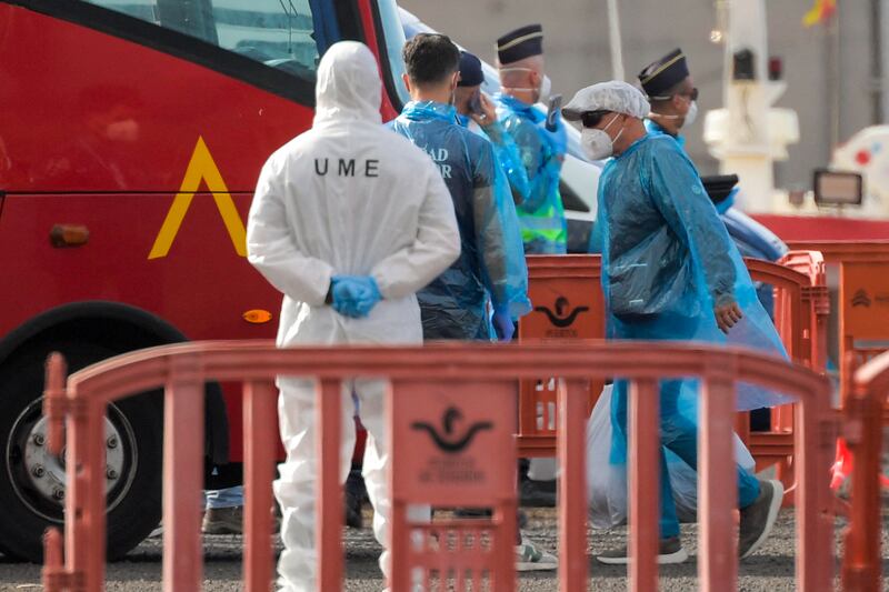 A passenger wearing a blue protective suits boards a military bus after being evacuated from the MV Hondius. Photograph: Jorge Guerrero/AFP via Getty