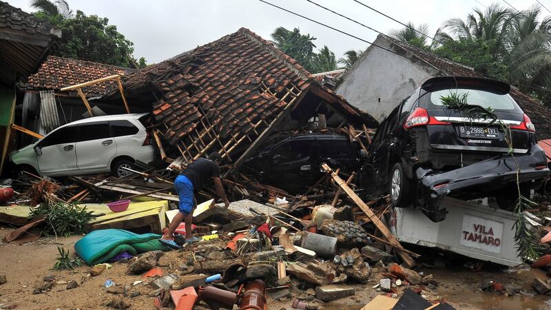 A resident searches for items among the ruins of a villa after the area was hit by a tsunami, at Carita beach in Padeglang, Banten province, Indonesia. Photograph: Antara Foto. Antara Foto/Asep Fathulrahman/ via REUTERS