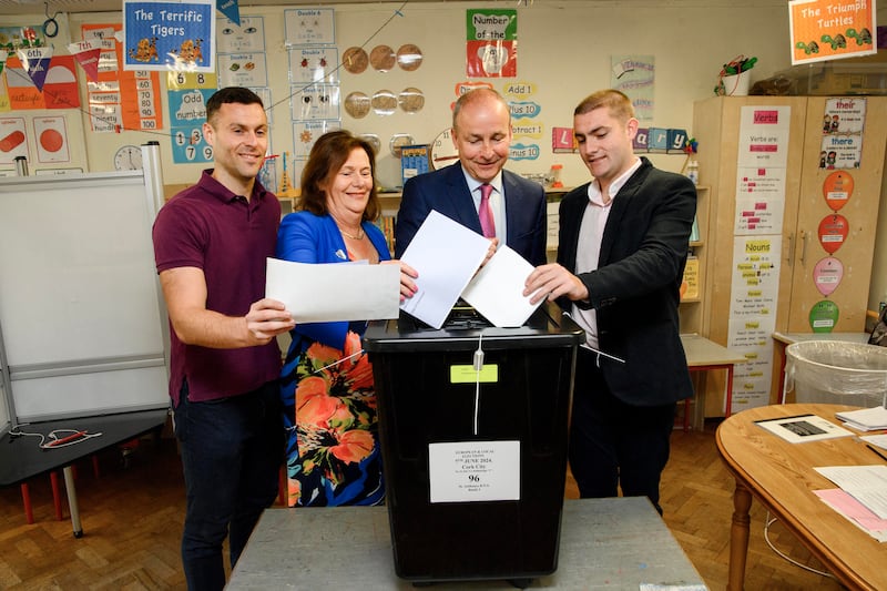 Tánaiste Micheál Martin with his wife Mary and sons Micheál Aodh and Cillian cast their votes at St Anthony's Boys National School in Ballinlough, Cork on Friday. Photograph: Daragh Mc Sweeney/Provision