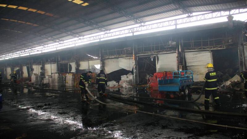 Firefighters clean a fire site inside an agricultural products wholesale market in Shenzhen, Guangdong province. Photograph: China Daily/Reuters