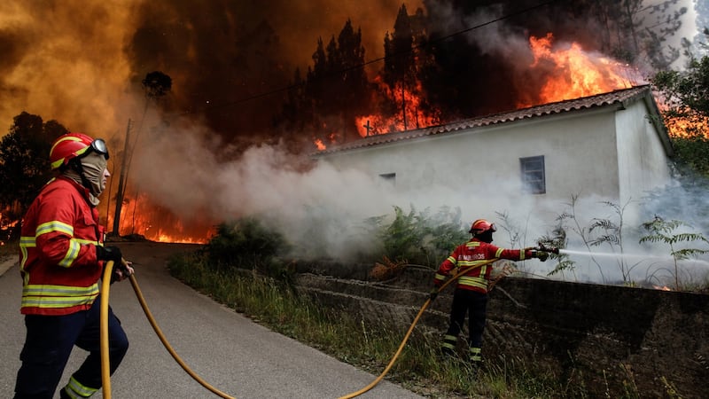 Firefighters battle with a fire. At least 61 people have been killed in forest fires in central Portugal. Photograph:  EPA/Paulo Cunha