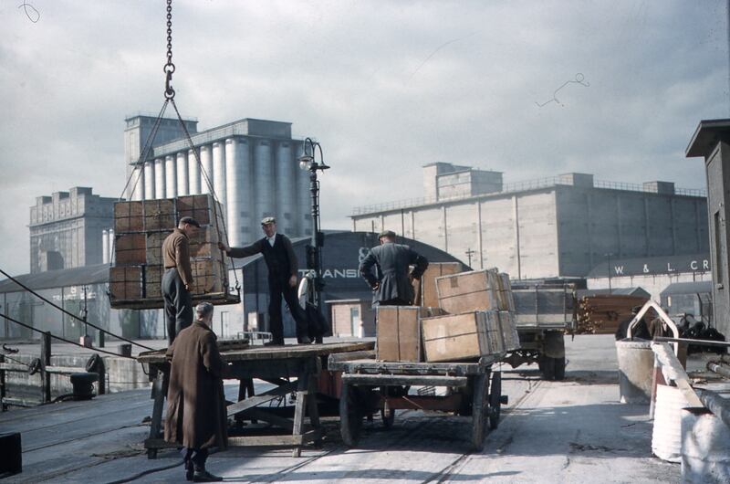 Cargo is loaded onto a trailer at the quayside as the Odlums Mill looms in the backgrounfd. Photograph: Dublin Port Archive