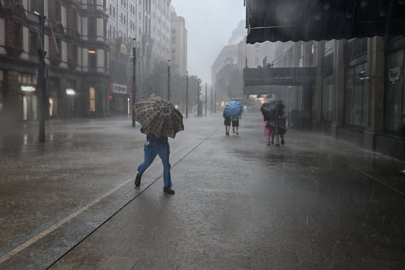 People use umbrellas to shelter from the rain on the Bund a day after Typhoon Dolphin made landfall in Shanghai on August 10, 2026. Photograph: Hector Retamal/AFP via Getty Images