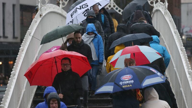 Pedestrians  crossing  the Ha’penny Bridge in Dublin city centre as heavy rain falls during Storm Dennis on Saturday. Photograph: Damien Eagers/The Irish Times.