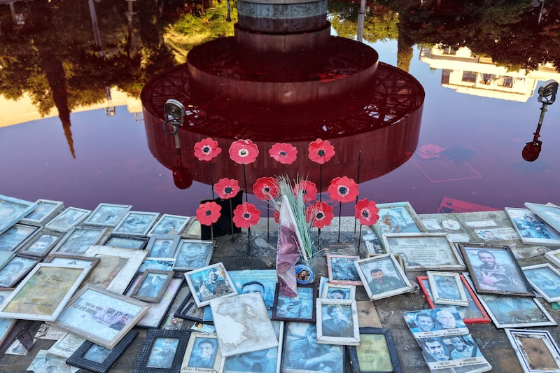 Portraits of Israeli victims are placed around the Dizengoff Fountain in Tel Aviv, which was filled with red dye. Photograph: Jack Guez/AFP via Getty Images