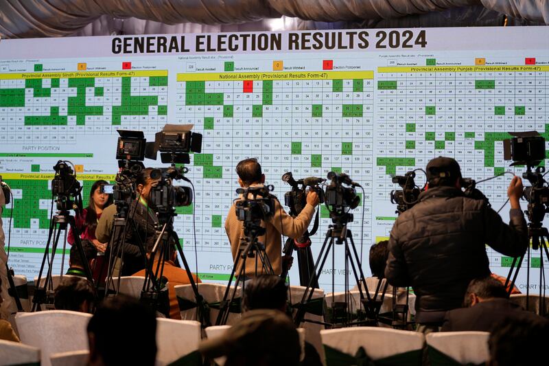 Cameramen film a big screen showing results of country’s parliamentary elections at the Pakistan Election Commission headquarters in Islamabad (Anjum Naveed/AP)