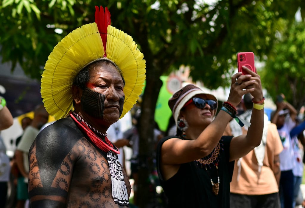 A woman takes snapshots during the so-called Great People's March in the sidelines of Cop30. Photograph: Pablo Porciuncula/AFP/Getty Images