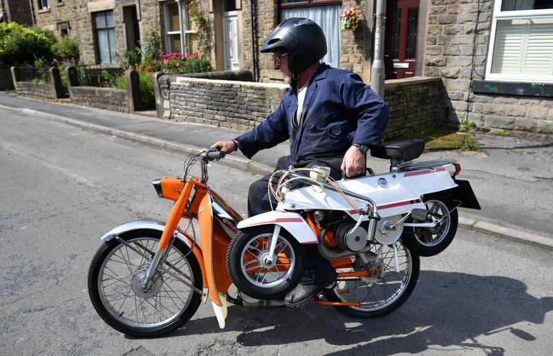 Peter Scragg rescues a suitcase motorbike from the School Garage after police allowed residents to collect items in Whaley Bridge. Photograph: Leon Neal/Getty Images
