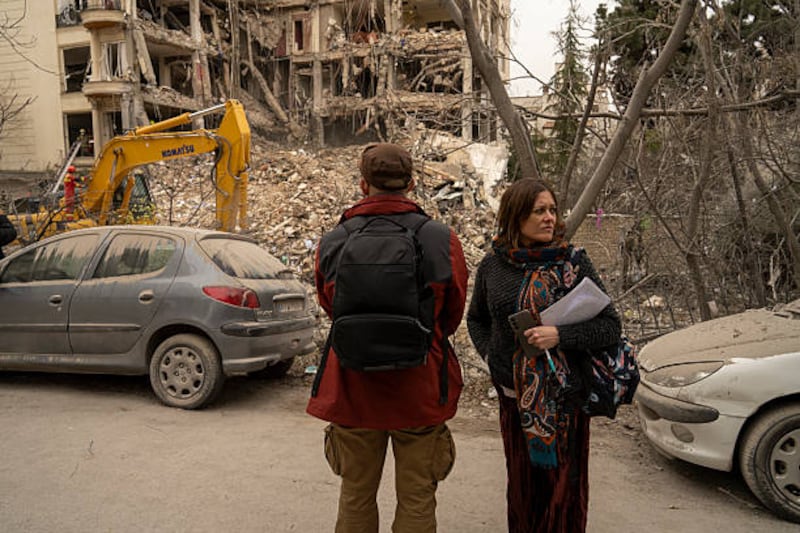 People gather near where rescue workers using heavy machinery clear debris from a destroyed residential building on Monday in northern Tehran, Iran. Photograph: Majid Saeedi/Getty