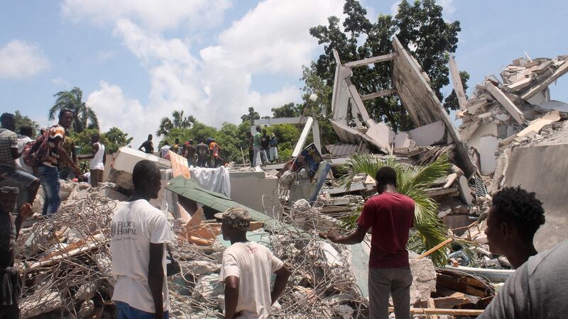 People search through the rubble of what used to be the Manguier Hotel in Les Cayes, southwest Haiti. Photograph: Stanley Louis/AFP via Getty