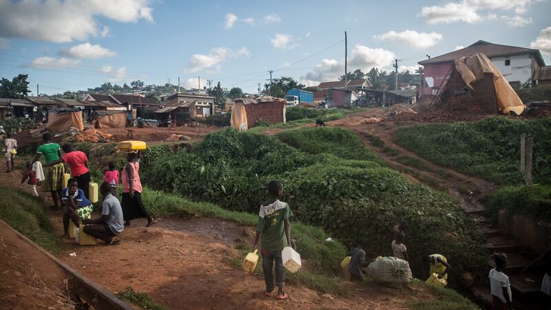 Residents of Namuwongo, Kampala, gather to carry water from a well. Most homes have no running water.  Photograph: Sally Hayden