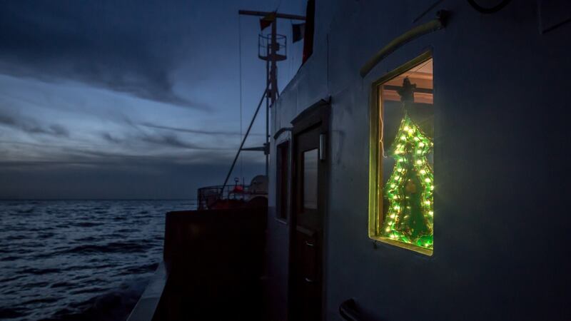 A Christmas tree light  in the window of the Alan Kurdi rescue vessel. Photograph: Sally Hayden