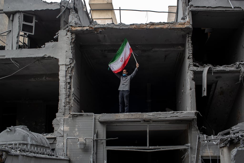 A man carrying the flag of Iran stands in a ruined apartment that was targeted by US-Israeli airstrikes in Tehran, Iran, on Sunday. Photograph: Arash Khamooshi/The New York Times
