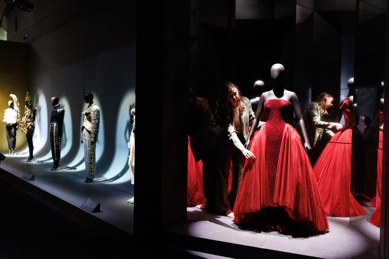 A gallery staff poses with custom haute couture dress, part of an exhibition 'Schiaparelli: Fashion Becomes Art' at Victoria and Albert Museum in London, Britain. The director of the museum said he wasn't attracted to the idea of charging entrance for overseas visitors.