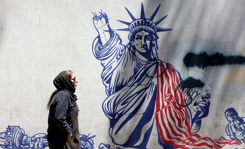 A woman walks next to an anti-US mural near the former US embassy in Tehran, Iran. Photograph: Abedin Taherkenareh/EPA
