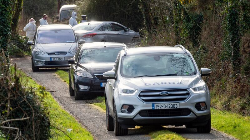 A Garda forensics team watches on as a hearse  leaves the farm off the Mitchelstown to Mallow Road outside Kildorrery, Co Cork, carrying the remains of two brothers discovered on nearby farmland. Photograph: Daragh McSweeney/Provision