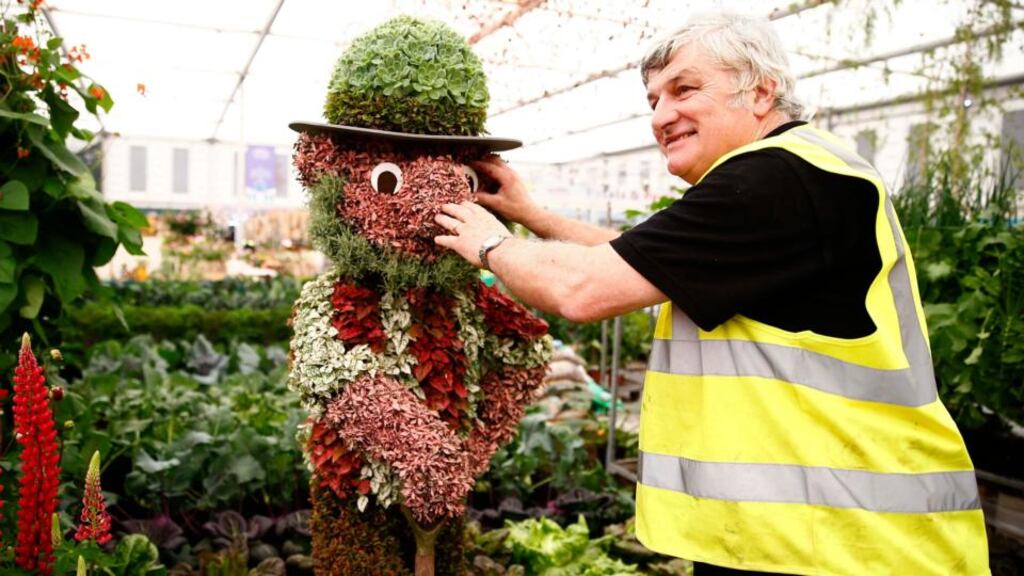 A stall holder attaches an eye to a figure on his display of edible leaves such as cabbages and lettuce at the Chelsea Flower Show in London today. Photograph: Reuters