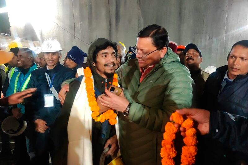Pushkar Singh Dhami (right), chief minister of the state of Uttarakhand, greets a worker rescued from the collapsed tunnel. Photograph: Uttarakhand State Department of Information and Public Relations via AP