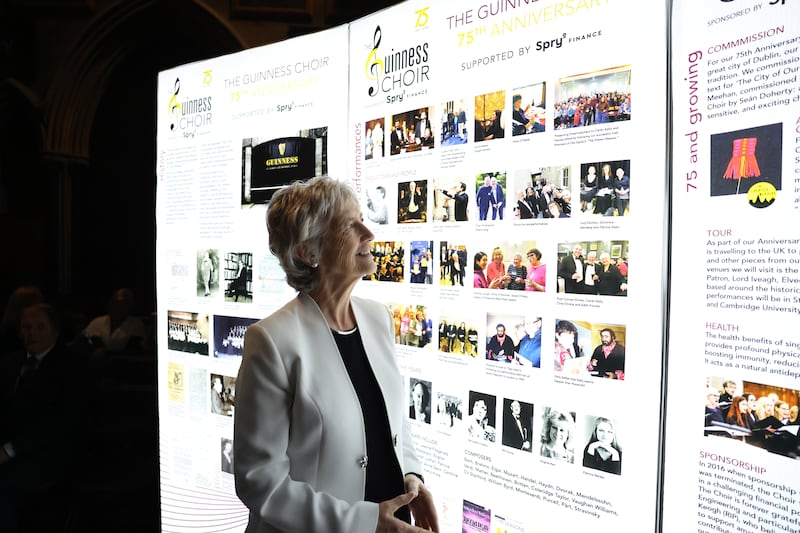 At a reception at the Mansion House, Dublin, President Catherine Connolly looks at a display celebrating the Guinness Choir's 75th year
