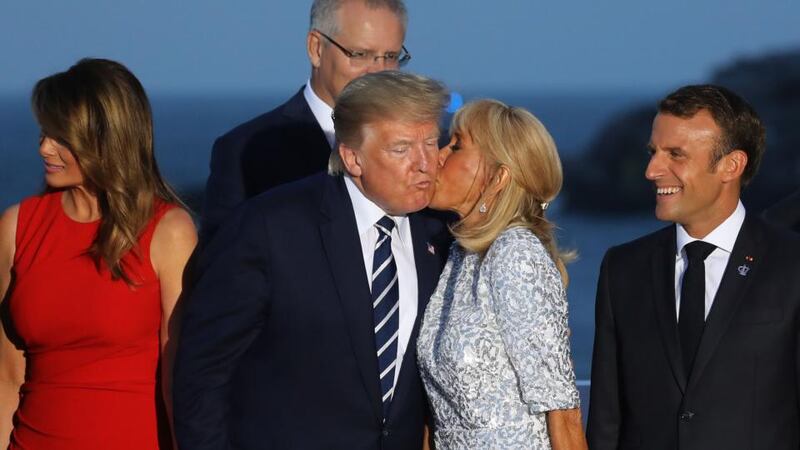 Brigitte Macron, wife of French president Emmanuel Macron,  kisses Donald Trump, flanked by Melania Trump and  Mr Macron. Photograph: Ludovic Marin/AFP/Getty
