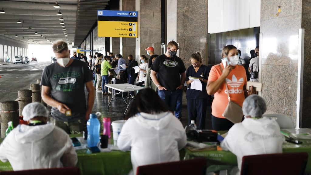 Passengers queue to register at a South Africa health department mobile coronavirus testing unit outside O R Tambo International Airport departures in Johannesburg.  South Africa’s government has drawn criticism over its Covid-19 vaccine roll-out plan, with unions and medical groups among those to have expressed concern about the sluggishness of the state’s response amid a resurgence in cases, hospitalisations and deaths. Photograph: Guillem Sartorio/Bloomberg