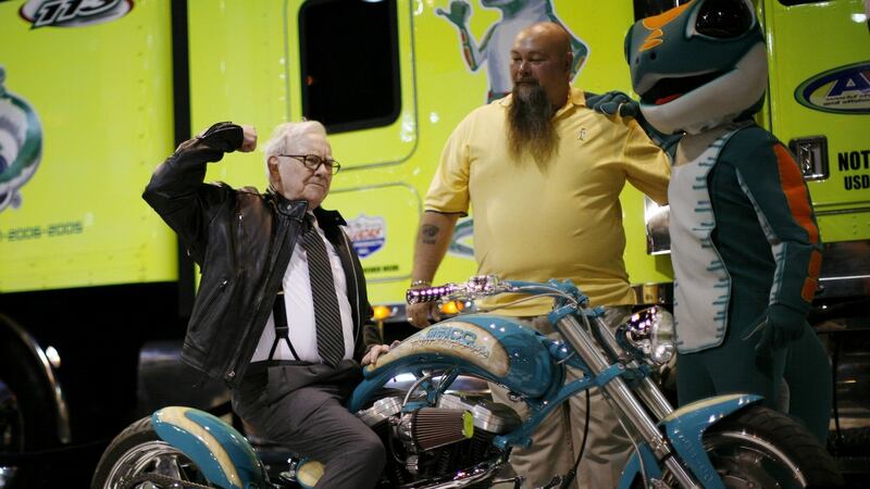 Warren Buffett poses on a motorcycle during a  Berkshire Hathaway Annual Shareholders meeting in Omaha, Nebraska.