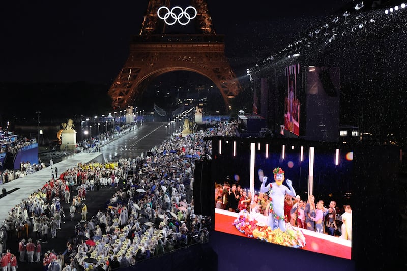 Spectators watch Philippe Katerine performing on a giant screen during the opening ceremony of the Paris 2024 Olympic Games. Photograph: Photograph: Ludovic Marin/Pool/AFP via Getty Images