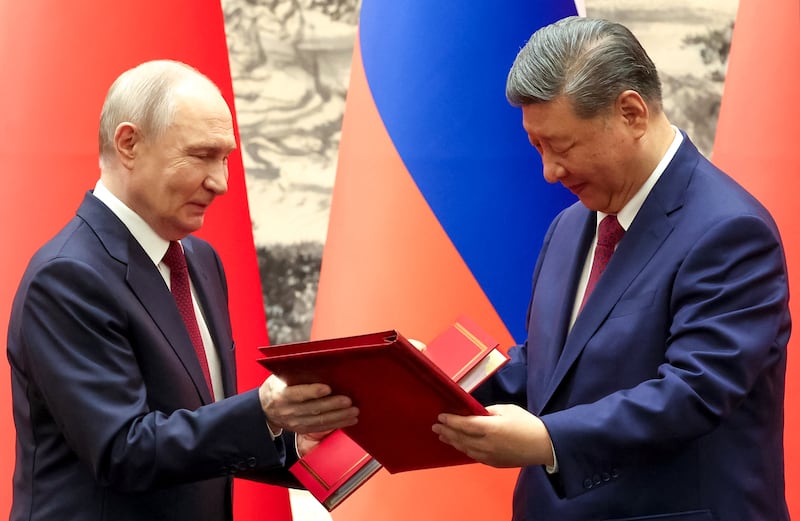 Vladimir Putin and Xi Jinping exchange documents following a signing ceremony in Beijing. Photograph: Alexander Kazakov/AFP via Getty Images