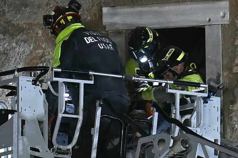 Rescuers evacuate the worker who was trapped in the Torre dei Conti after the tower partially collapsed. Photograph: Filippo Monteforte/AFP via Getty Images  