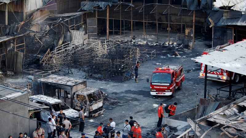 Fire fighters and policemen as seen inside an explosion at the fireworks factory. Photograph: Beawiharta/Reuters