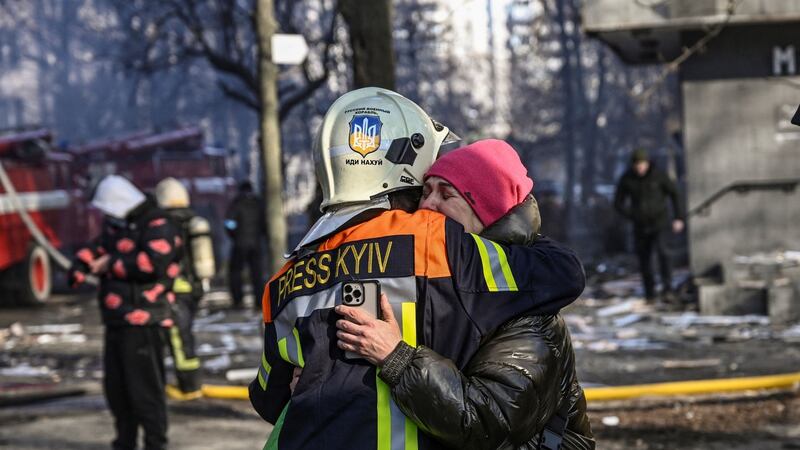 A fireman embraces a woman outside a damaged apartment building in Kyiv  after strikes on residential areas.  Photograph: Aris Messinis/AFP via Getty