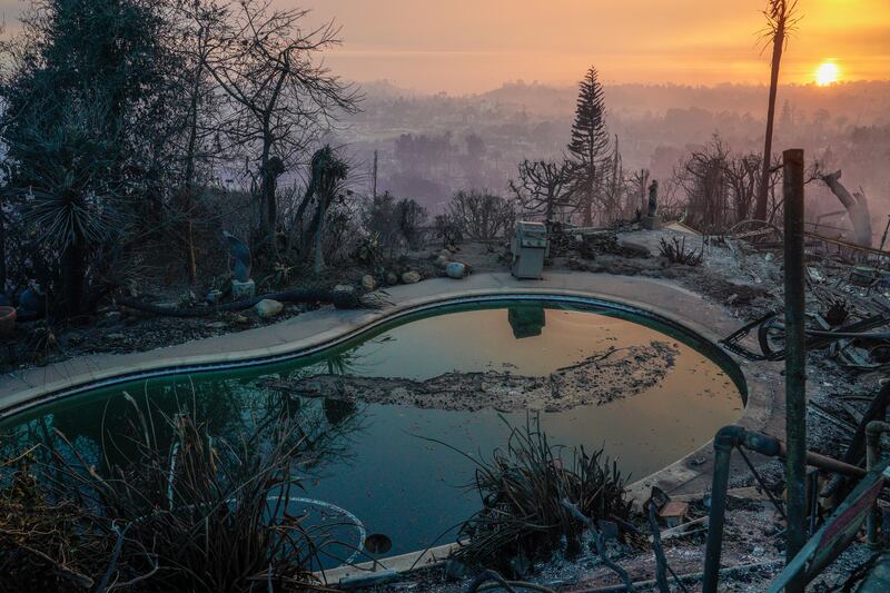 The sun sets over destroyed homes during the Palisades fire last week. Photograph: Kyle Grillot/The New York Times
                      
