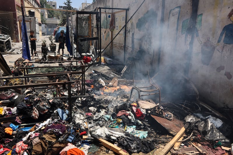 Children look at smouldering debris at Gaza City's Mustafa Hafez school, which has been sheltering Palestinians displaced by the war. Photograph: Omar Al-Qattaa/Getty