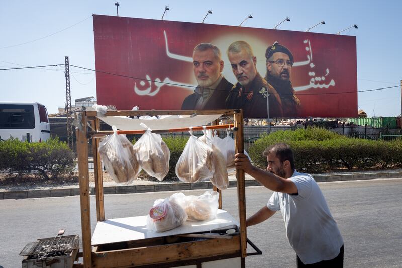 A man pushes his food cart in Beirut in front of a billboard depicting three assassinated figures: Hamas leader Ismail Haniyeh, Gen Qasem Soleimani of Iran's Revolutionary Guard and Hizbullah top commander Fuad Shukr. Photograph: Chris McGrath/Getty Images