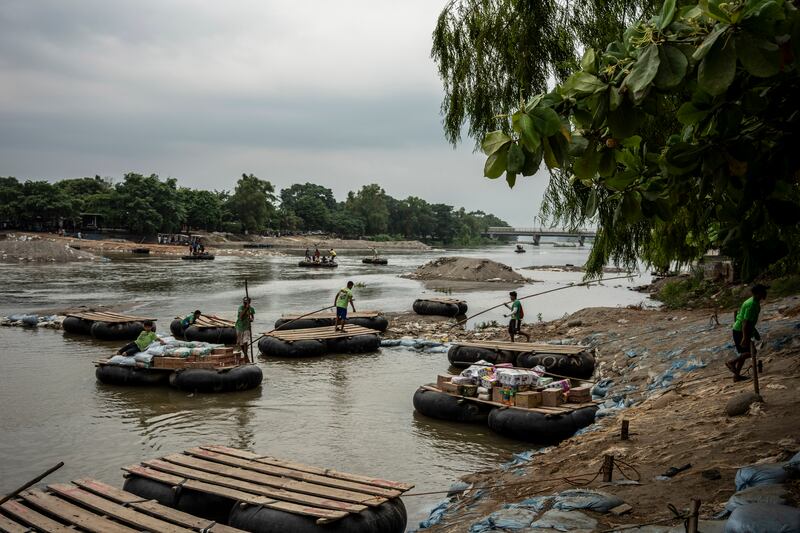 Workers transporting merchandise across the Suchiate river between Mexico and Guatemala. Photograph: Cesar Rodriguez/ New York Times