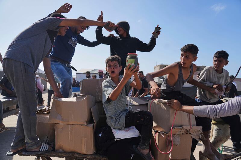 Palestinians carry boxes containing food and humanitarian aid packages delivered by the Gaza Humanitarian Foundation. Photograph: Abdel Kareem Hana/AP