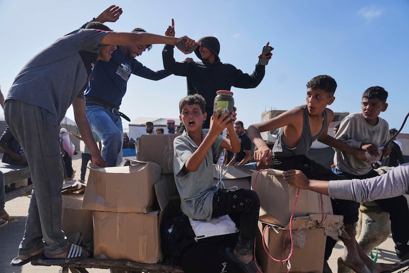 Palestinians carry boxes containing food and humanitarian aid packages delivered by the Gaza Humanitarian Foundation. Photograph: Abdel Kareem Hana/AP
